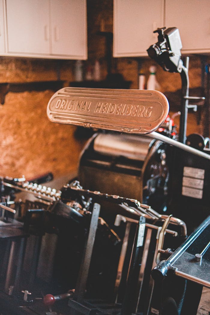 Close-up of a classic Heidelberg letterpress machine in a cozy workshop setting.